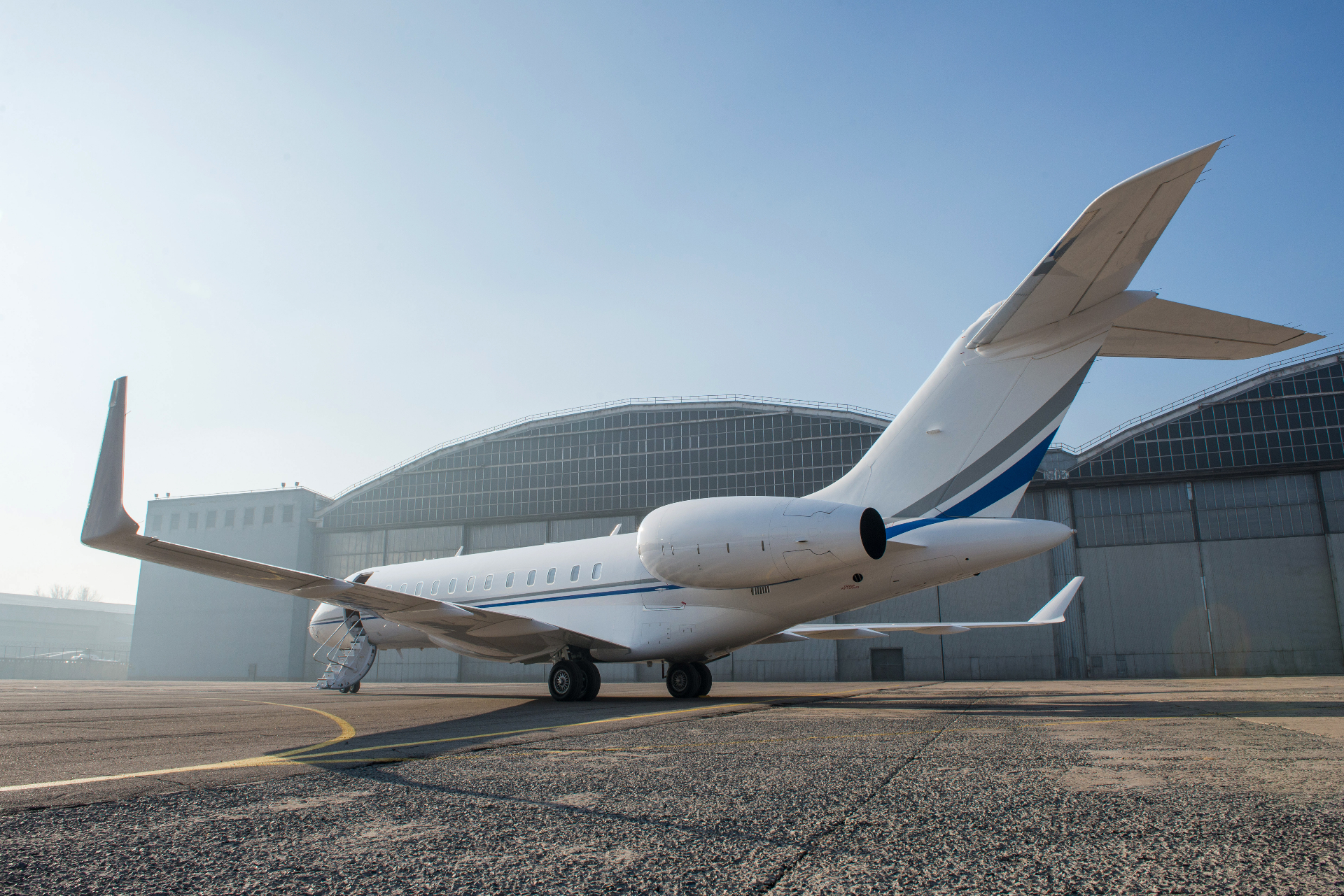 Private jet parked in front of an aircraft hangar